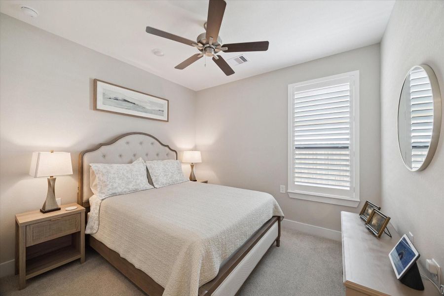Inviting guest room with warm neutral tones, plush carpeting, and stylish finishes that blend comfort and sophistication.