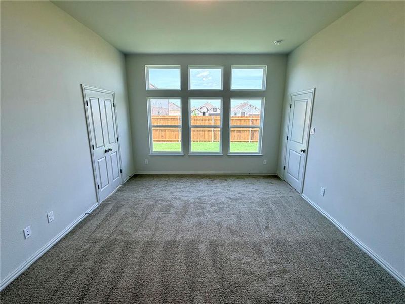 Spacious room featuring broadloom carpeting and light gray wall finishes