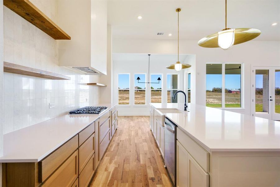 Kitchen with appliances with stainless steel finishes, light hardwood / wood-style floors, a healthy amount of sunlight, and sink