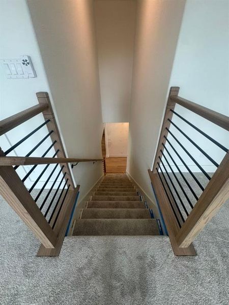 Carpeted staircase with contemporary wood and metal balusters