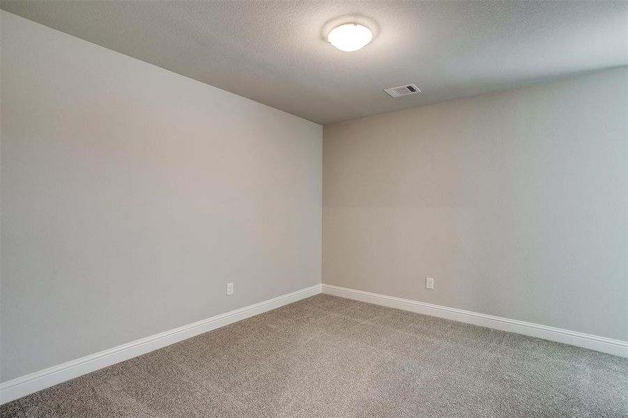 Carpeted spare room featuring a textured ceiling