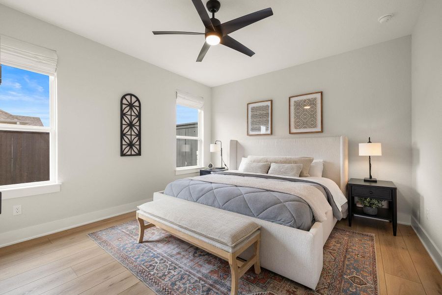 Comfortable secondary bedroom with bright windows and neutral tones.