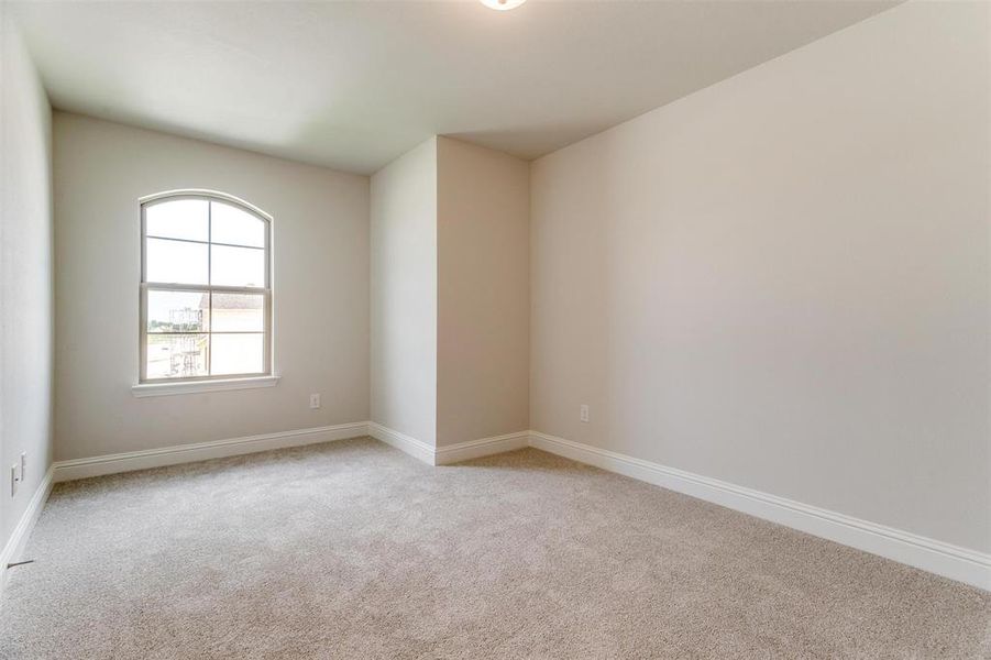 Spare room with light colored carpet and baseboards