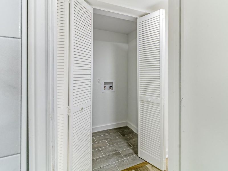 Laundry area featuring hookup for a washing machine and wood finish floors Laundry area featuring hookup for a washing machine and wood finish floors