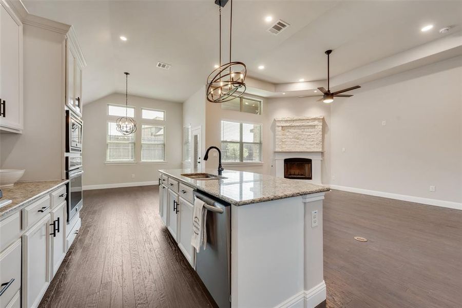 Kitchen with white cabinetry, a fireplace, open floor plan, dark wood finished floors, and recessed lighting Kitchen with white cabinetry, a fireplace, open floor plan, dark wood finished floors, and recessed lighting