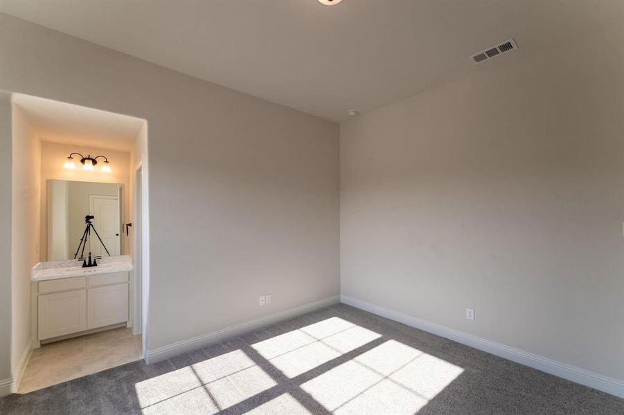 Unfurnished bedroom featuring sink, connected bathroom, and light tile patterned floors