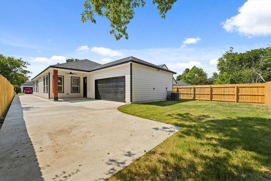 View of side of property featuring a garage, driveway, and a shingled roof View of side of property featuring a garage, driveway, and a shingled roof