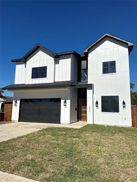 View of front of property featuring a garage and a front yard