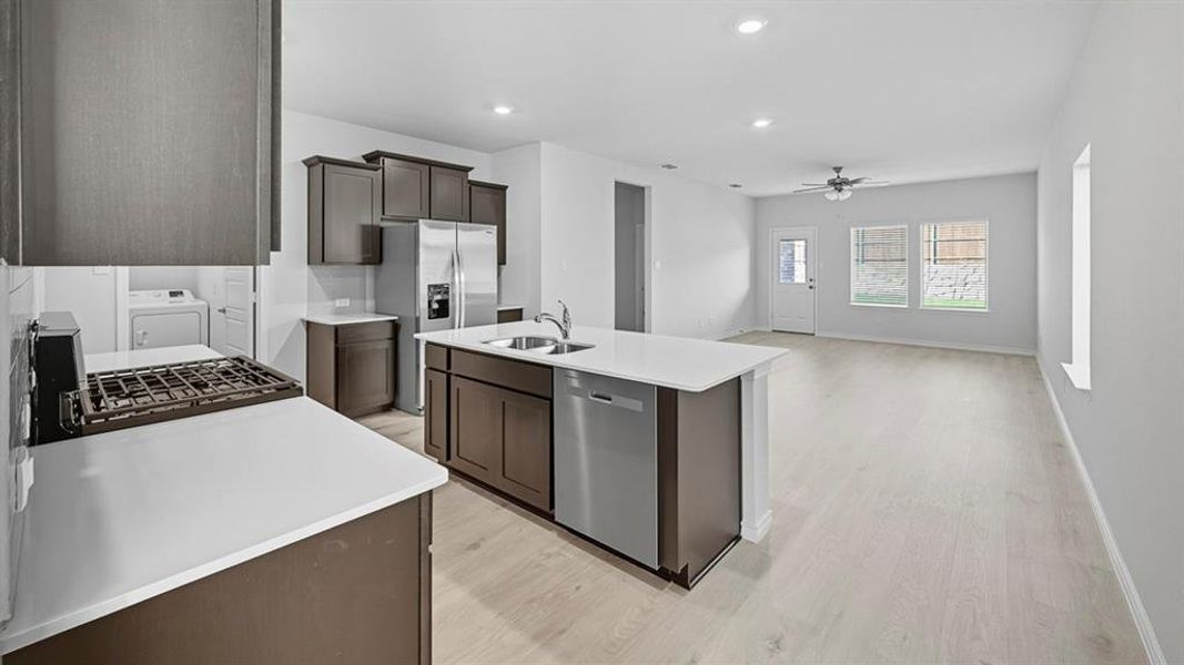 Kitchen with appliances with stainless steel finishes, an island with sink, recessed lighting, a ceiling fan, and light wood-style flooring