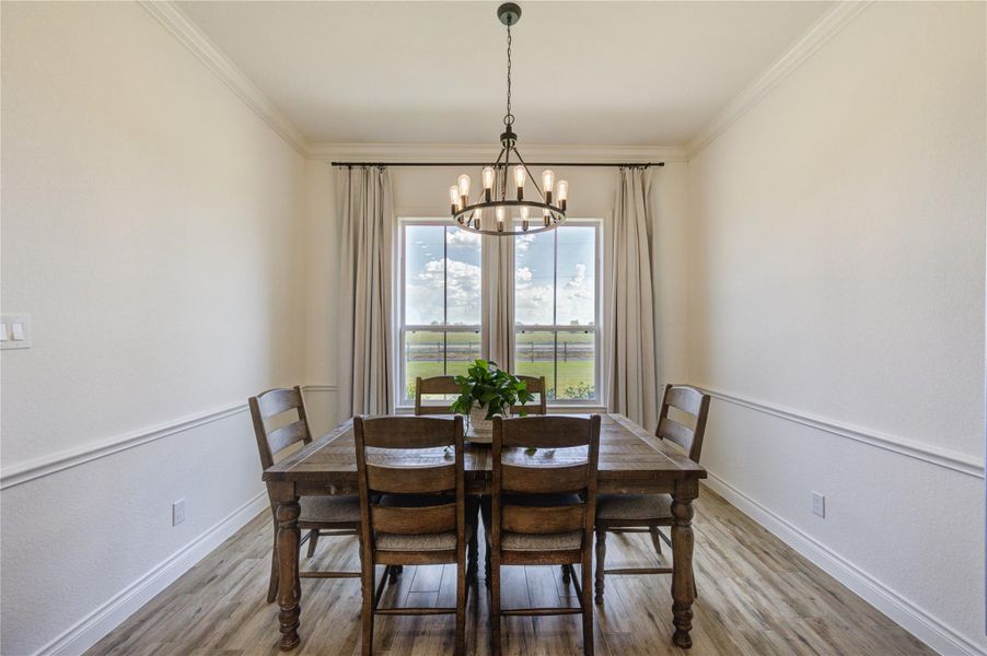 Dining room with large windows offering peaceful countryside views and plenty of natural light.