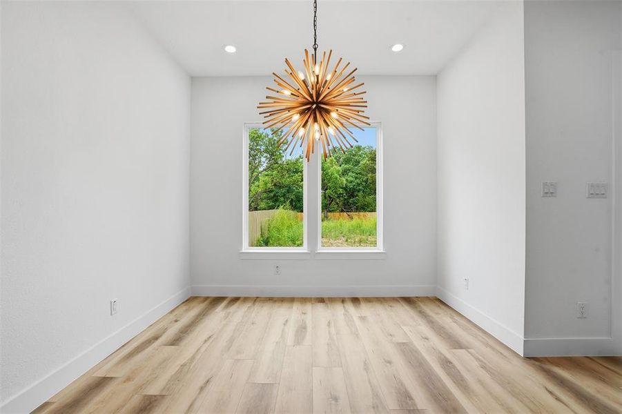 Room featuring a contemporary sputnik chandelier, wood-finish flooring, and recessed ceiling lighting