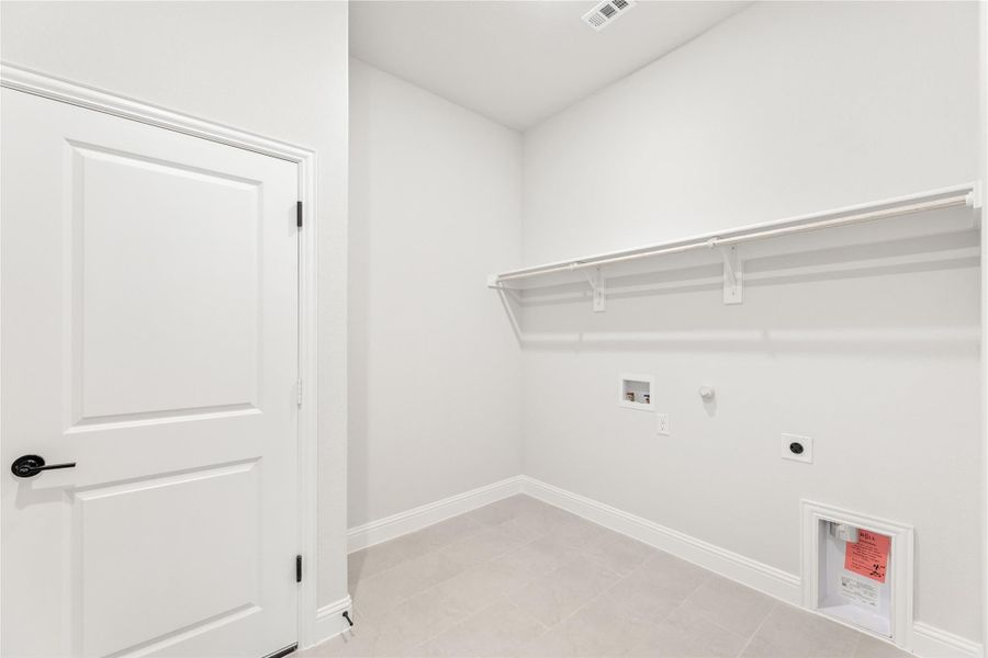 Laundry room with white walls, built-in shelf, washer and dryer hookups, and tile floor Laundry room with white walls, built-in shelf, washer and dryer hookups, and tile floor