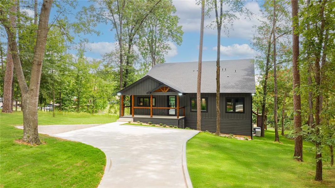 View of front of home with covered porch, board and batten siding, a front lawn, and a shingled roof View of front of home with covered porch, board and batten siding, a front lawn, and a shingled roof