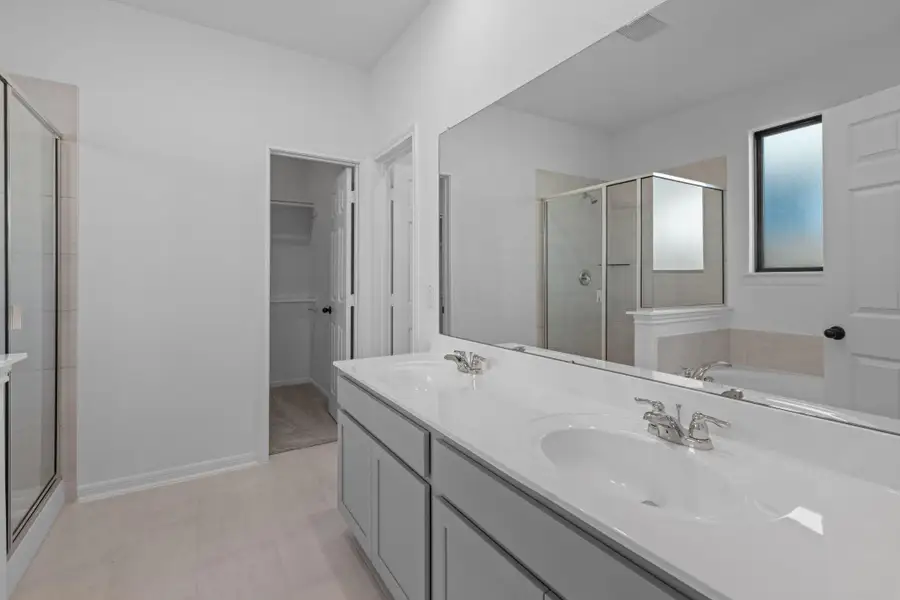 The en-suite bathroom offers a spa-like atmosphere with its elegant design, high end finishes, and tasteful lighting, creating a retreat within your own home.