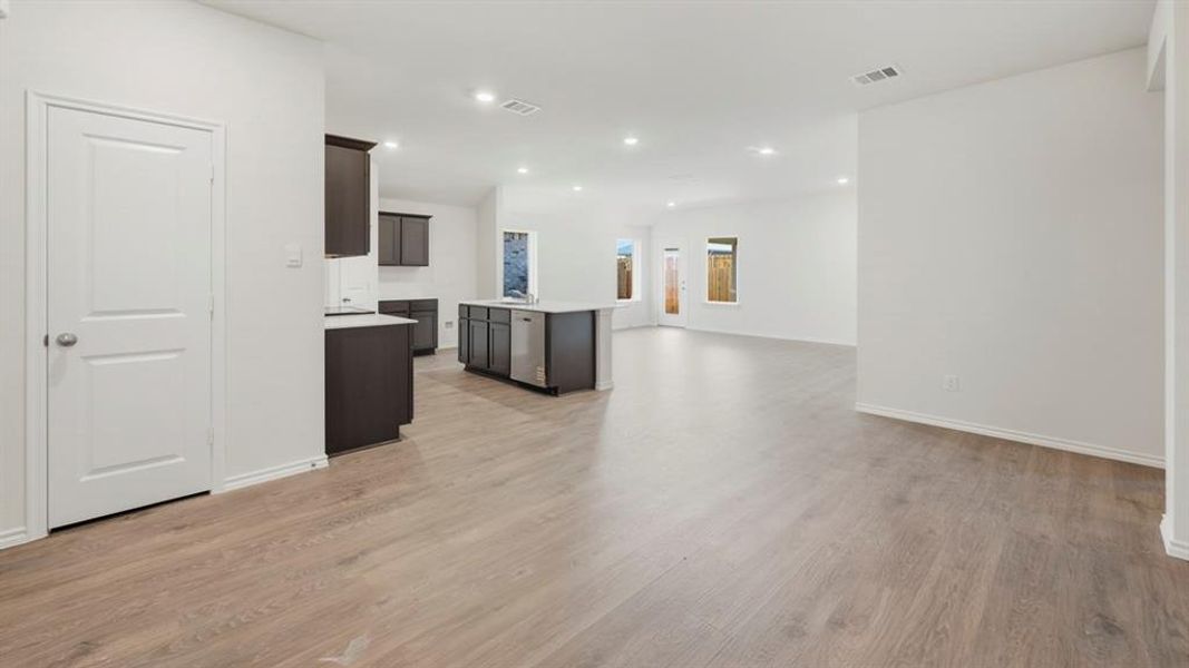 Kitchen with an island with sink, open floor plan, light wood-type flooring, recessed lighting, and dishwasher Kitchen with an island with sink, open floor plan, light wood-type flooring, recessed lighting, and dishwasher