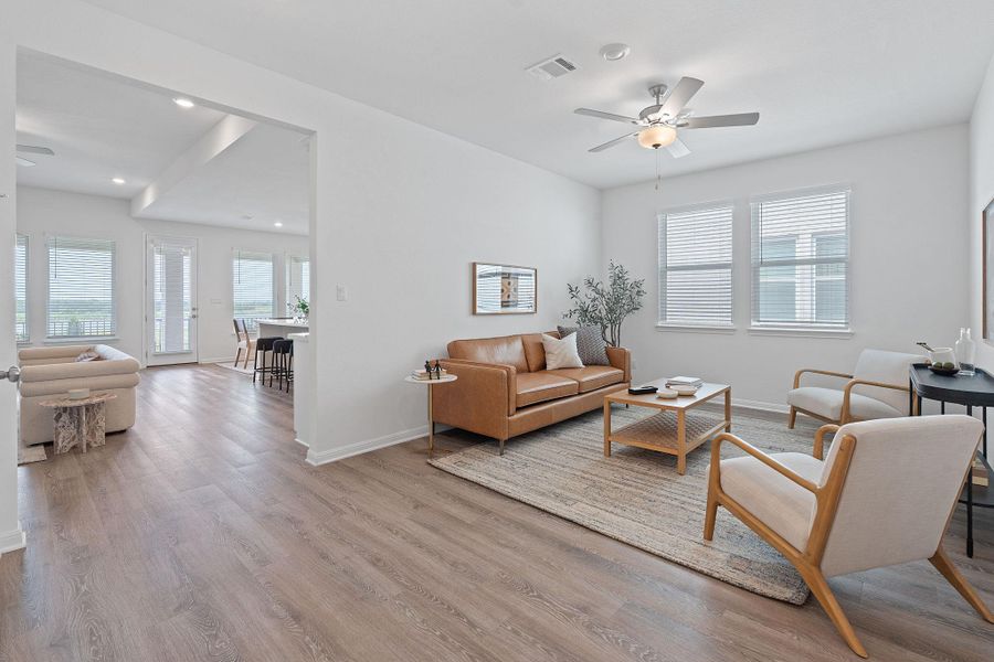 Living room featuring ceiling fan, light wood finished floors, baseboards, and recessed lighting