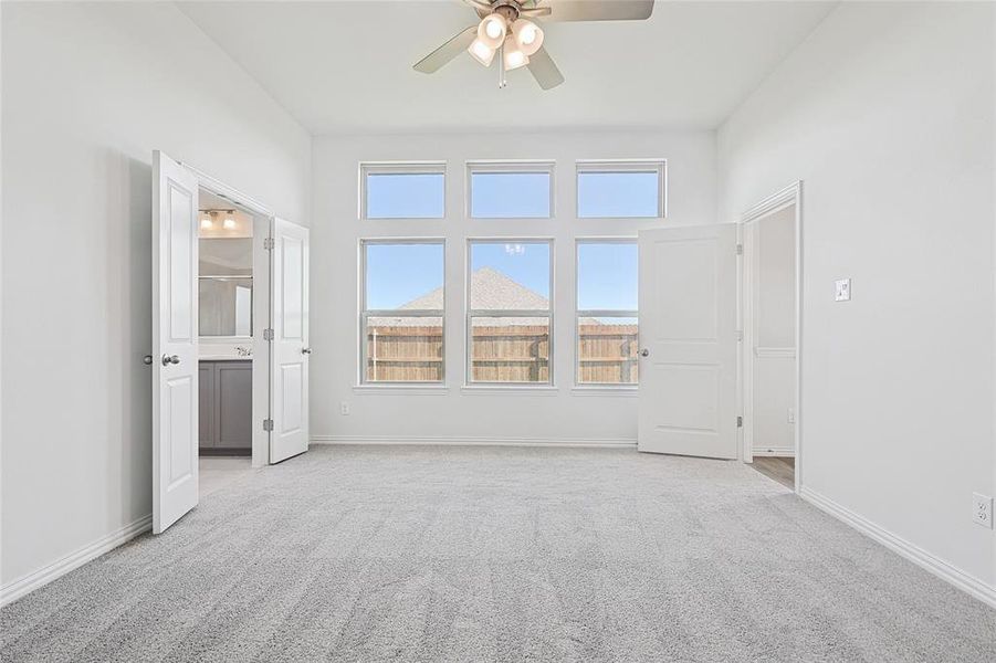 Unfurnished room featuring light carpet and ceiling fan