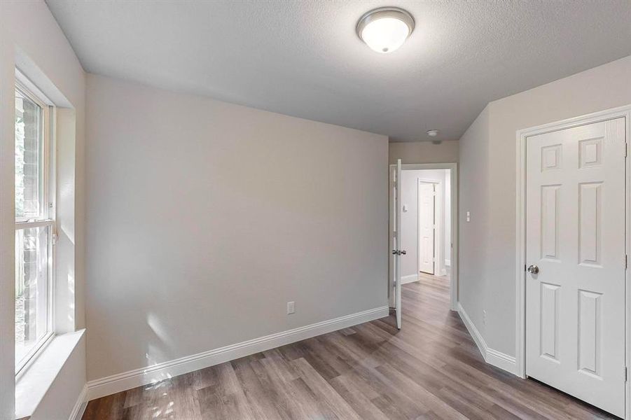 Unfurnished bedroom with a closet, a textured ceiling, and hardwood / wood-style floors