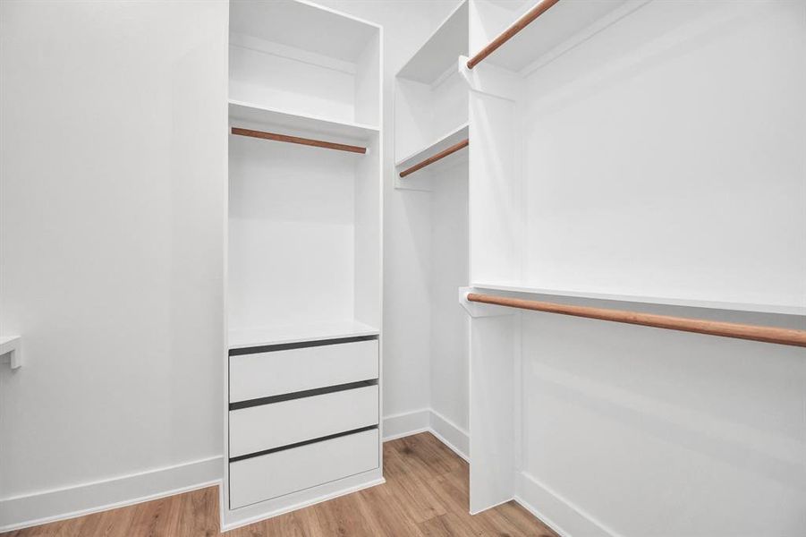 Dream-worthy walk-in closet with built-in shelving for all your needs.