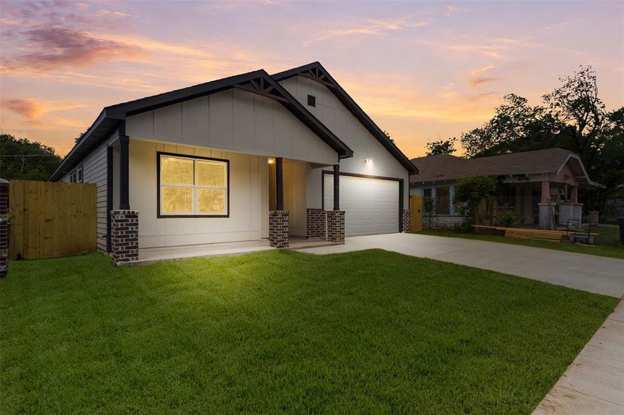 Contemporary exterior featuring white siding, dark trim, and a prominent front-facing garage