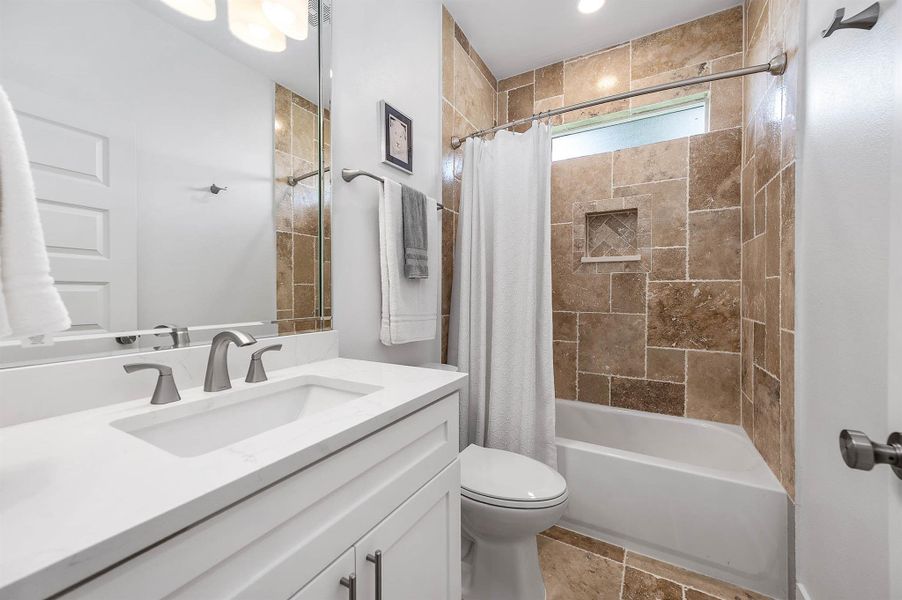 Conveniently located between the secondary bedrooms, this bright and modern bathroom features neutral finishes, and a tiled shower/tub combination designed for both style and functionality.