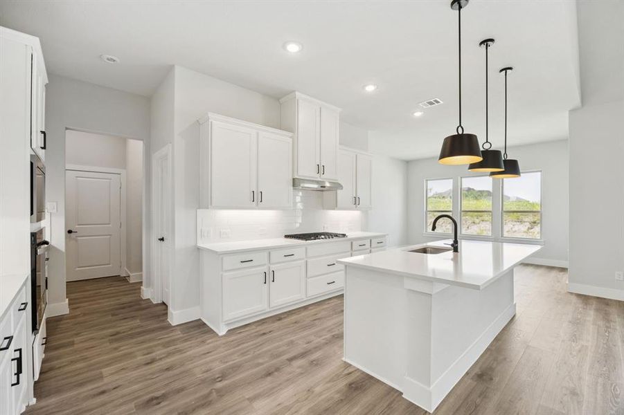 Kitchen with decorative backsplash, white cabinets, decorative light fixtures, recessed lighting, and light wood finished floors