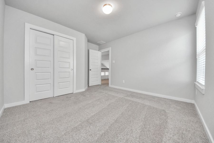 Generously sized secondary bedrooms featuring spacious closets, soft and inviting carpeting underfoot, large windows allowing plenty of natural light, and the added touch of privacy blinds for your personal retreat. Sample photo of completed home with similar floor plan. Actual colors and selections may vary.