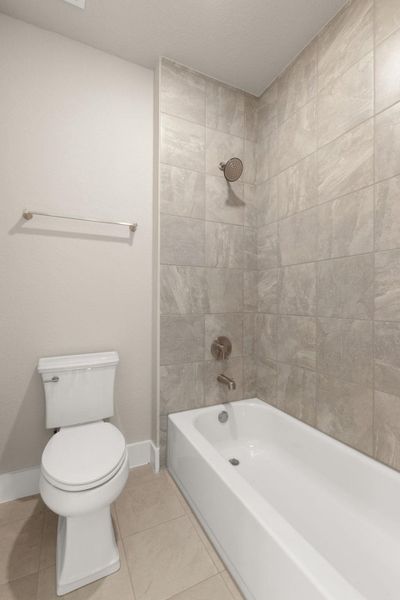 Bathroom featuring light tile patterned flooring and washtub / shower combination