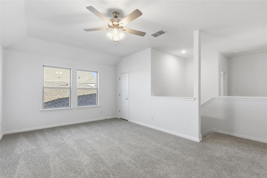 Unfurnished room with light carpet, a ceiling fan, and vaulted ceiling