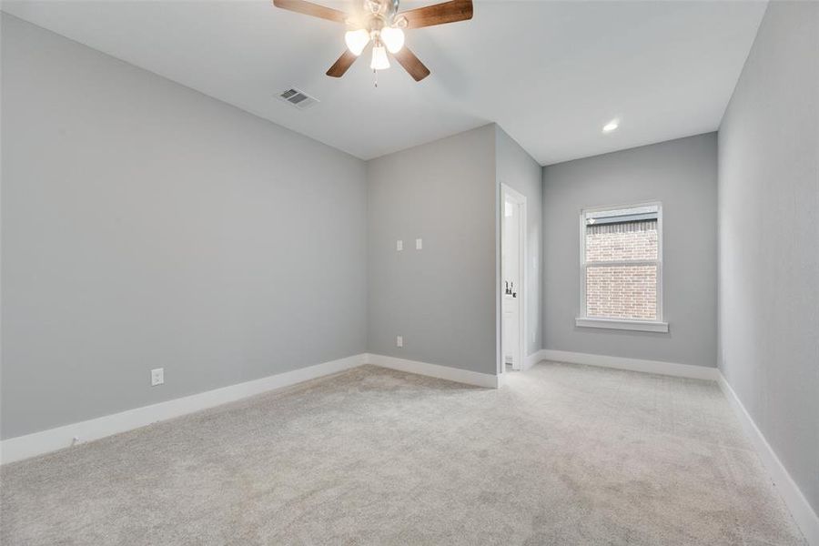 Carpeted empty room featuring ceiling fan