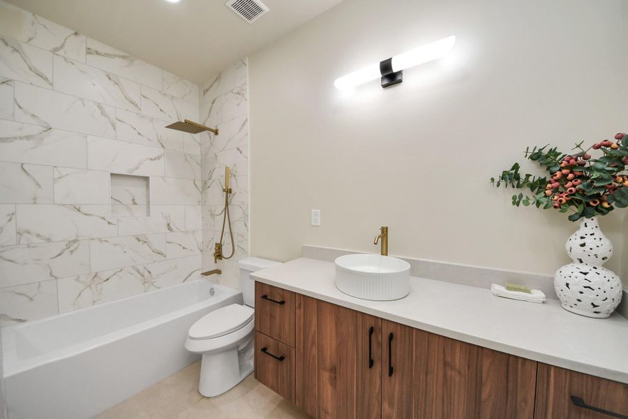 Consistent designer touches in the guest bath maintain the home's high-end feel.