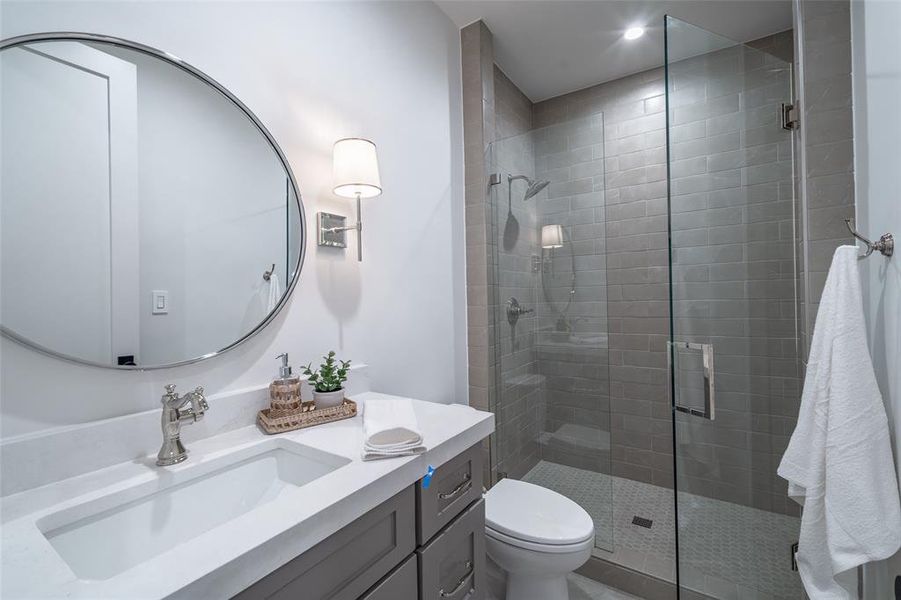 Bathroom featuring vanity, an enclosed shower, and toilet