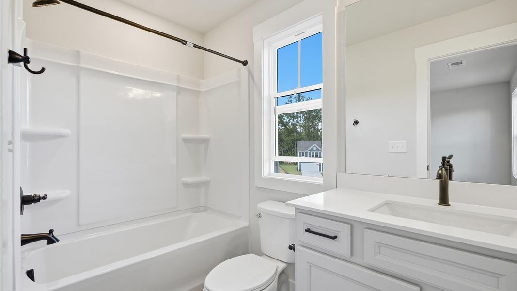 Stylish guest bathroom with superior design and thoughtful storage solutions at Creeks at Midway