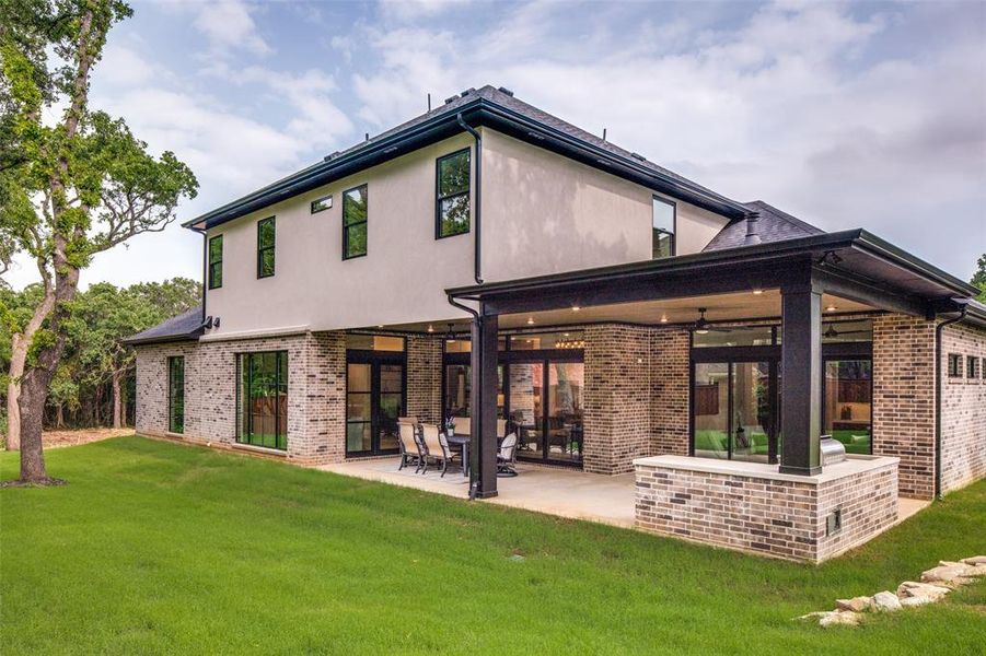 Rear view of property with a patio and a lawn