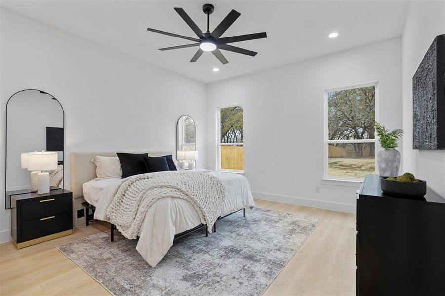 Bedroom with light wood-type flooring, ceiling fan, and recessed lighting