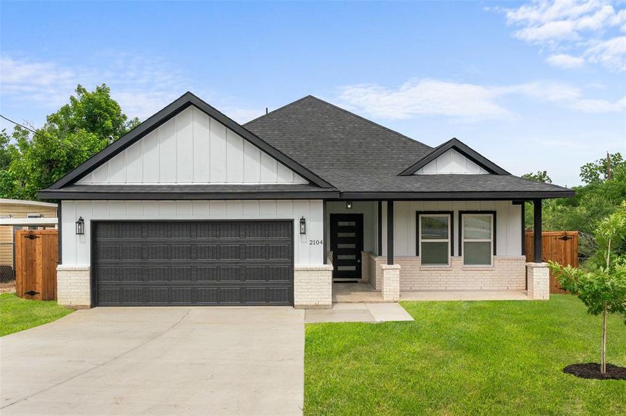 View of front of home featuring brick siding, a shingled roof, and an attached garage View of front of home featuring brick siding, a shingled roof, and an attached garage