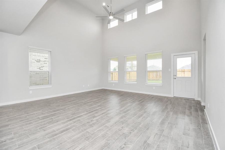 Bring your loved ones and guests together in the inviting living room! Boasting lofty high ceilings, recessed lighting, a stylish ceiling fan, custom paint, stunning flooring, and expansive windows that flood the space with ample natural light all day long.