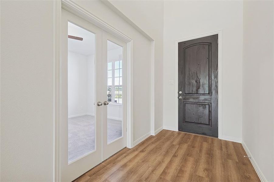 Entrance foyer featuring french doors and wood finished floors
