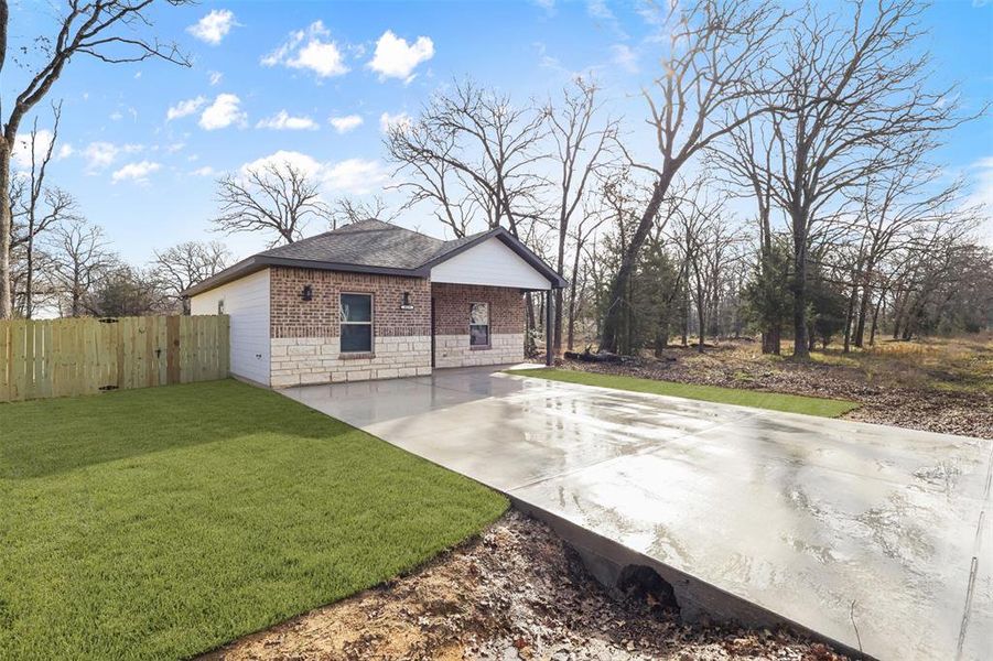 View of home's exterior with a lawn and a patio