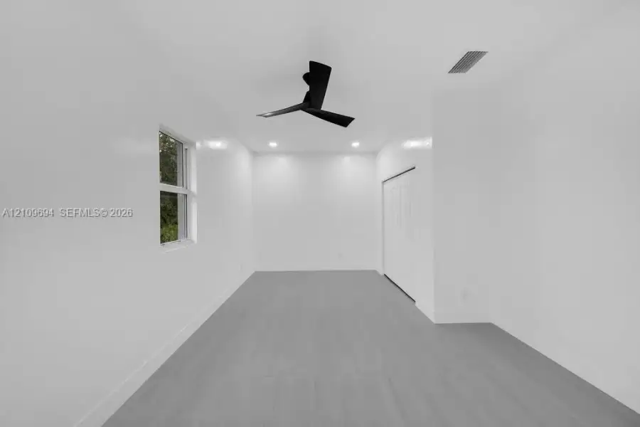 Interior space featuring neutral wall paint, wood-finish flooring, recessed lighting, a matte black ceiling fan, and a closet with bifold doors