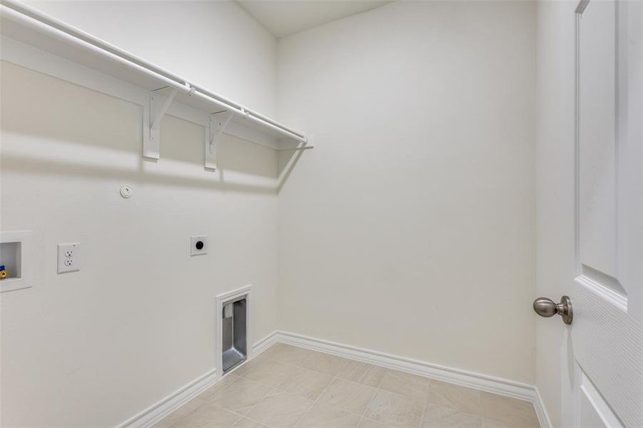 Laundry area with washer hookup, hookup for an electric dryer, gas dryer hookup, and light tile patterned floors Laundry area with washer hookup, hookup for an electric dryer, gas dryer hookup, and light tile patterned floors