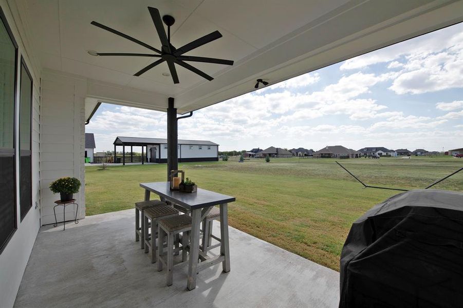 View of patio with a residential view, outdoor dining area, a ceiling fan, and grilling area