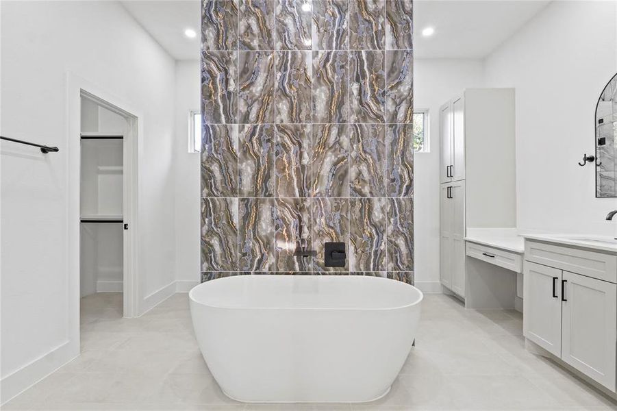 Full bathroom featuring vanity, a freestanding bath, light tile patterned floors, healthy amount of natural light, and recessed lighting