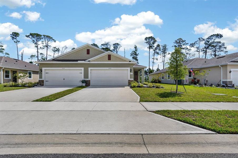 Front exterior of a new home in Halifax Plantation Villas, Ormond Beach, FL, highlighting curb appeal (Image 27).