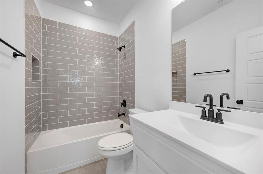 Full bath with vanity,  shower combination, and light tile patterned flooring