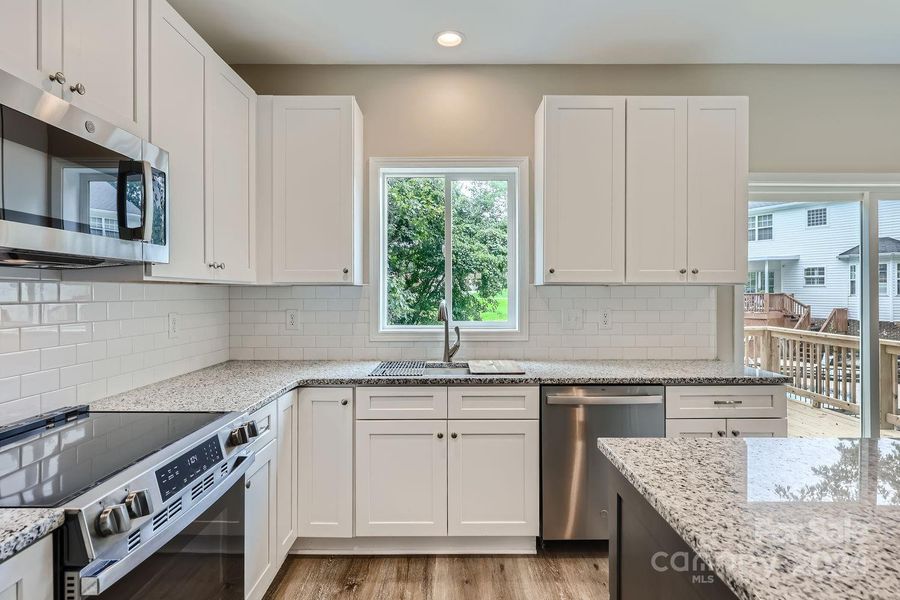 This sleek, modern kitchen boasts high-end appliances, granite countertops, and an open layout, making it a culinary haven perfect for both everyday meals and entertaining guests.