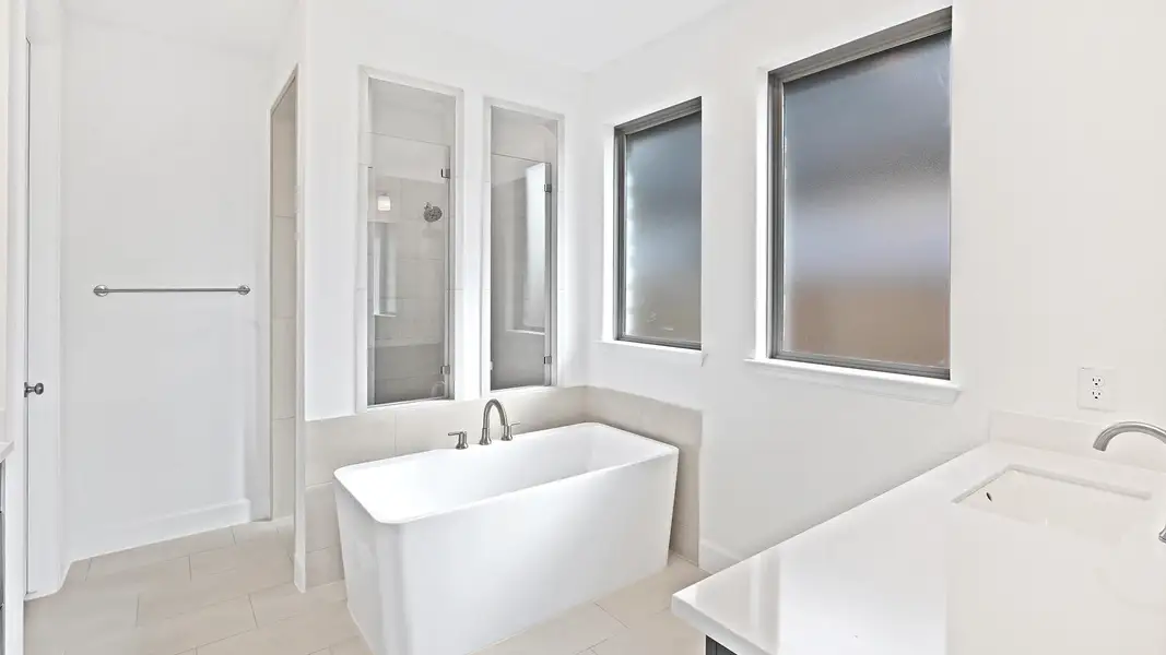 Bathroom featuring vanity, a stall shower, light tile patterned flooring, and a freestanding tub
