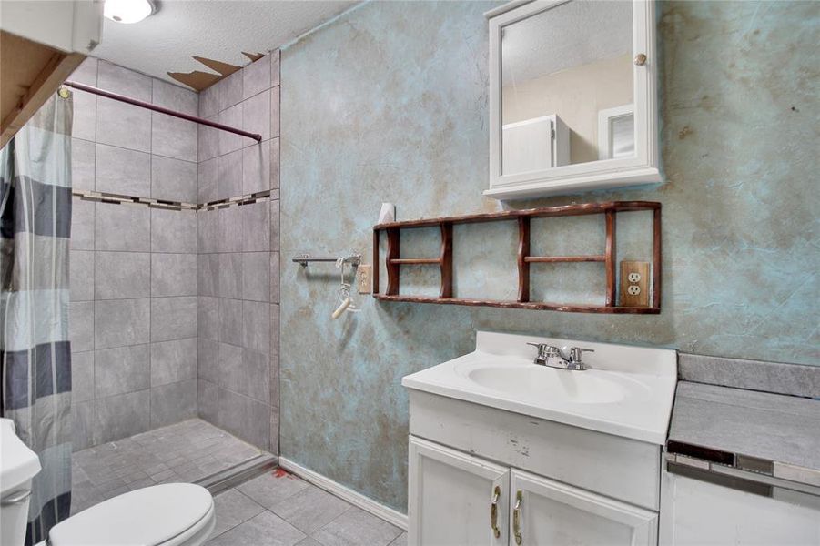 Bathroom with a stall shower, vanity, and light tile patterned floors Bathroom with a stall shower, vanity, and light tile patterned floors