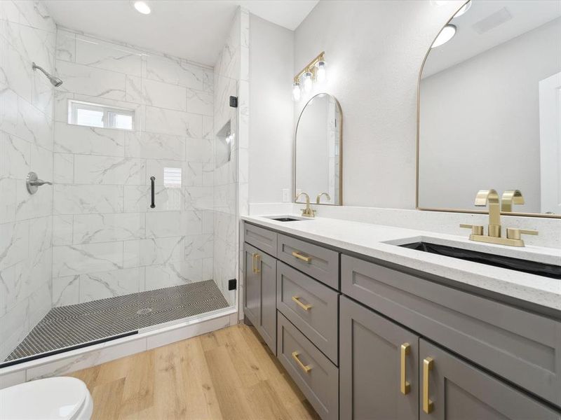 Bathroom featuring vanity, wood-type flooring, a shower with shower door, and toilet