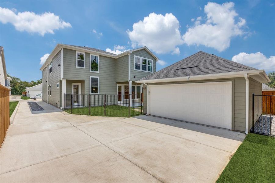 View of front of home featuring a garage, an outbuilding, and a front yard